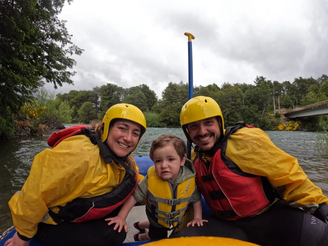 Familia con un niño equipada junto al río