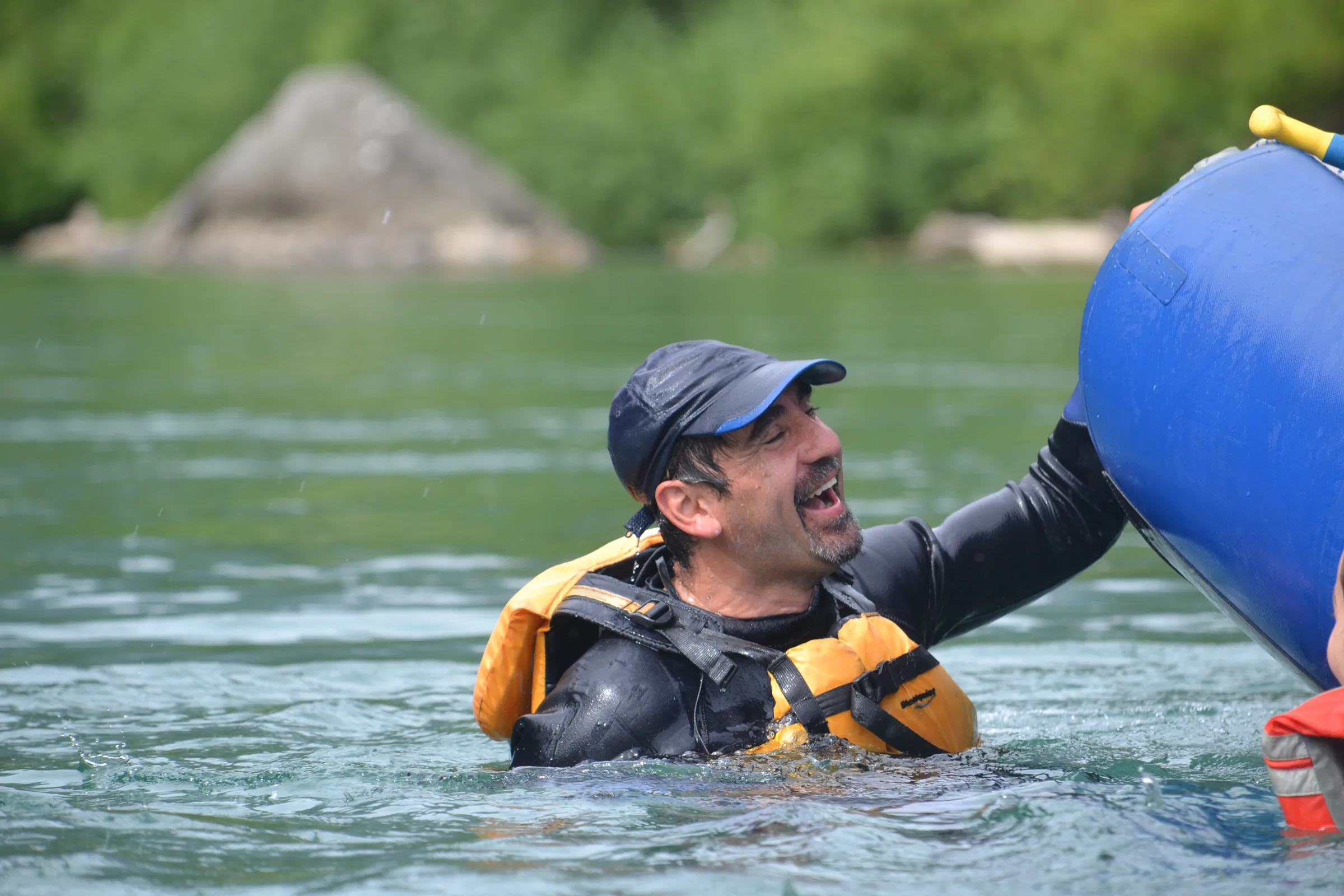 Cliente sonriendo mientras nada junto a la balsa